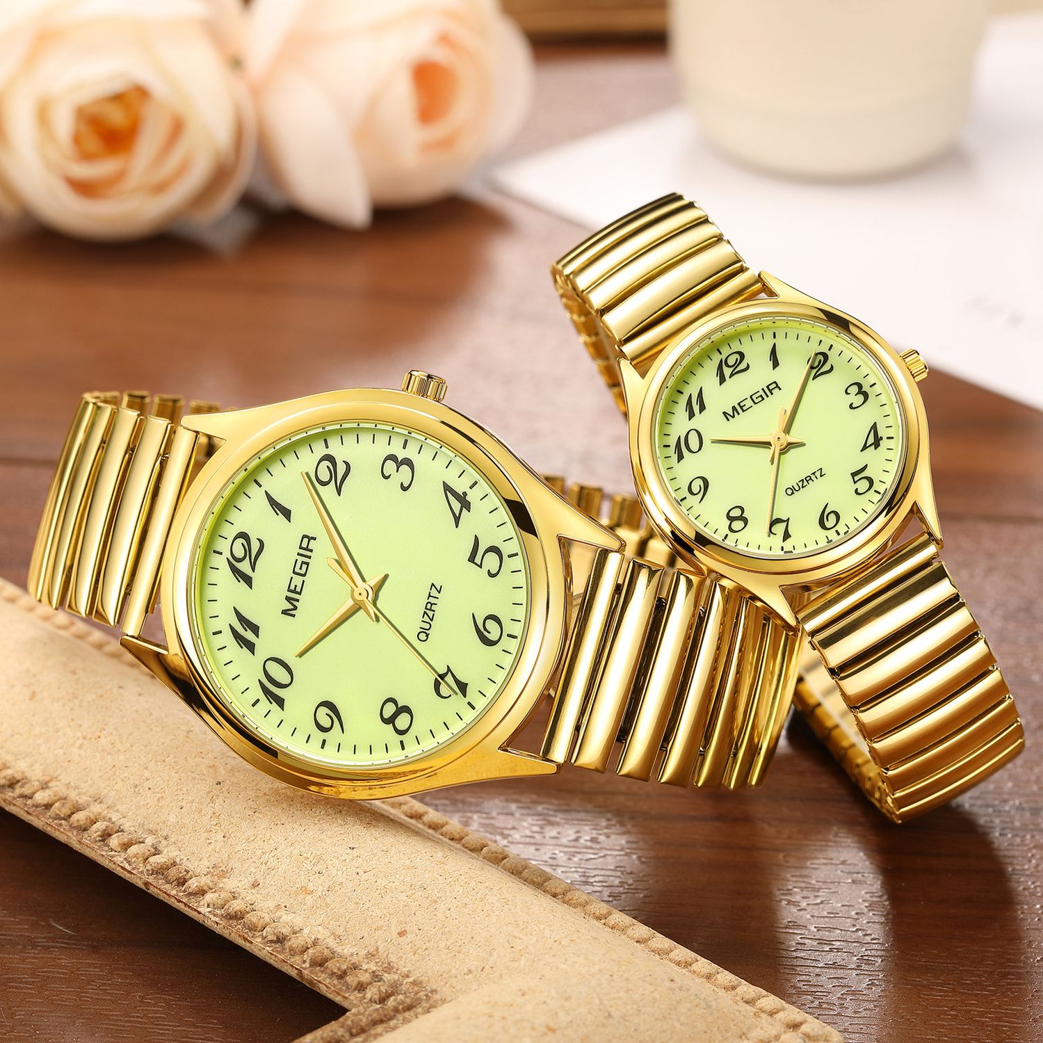 MEGIR 1088 unisex watch pair in gold-tone with luminous green Arabic-numeral dials and stretch bracelets