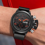 MEGIR 2002 men's chronograph watch on the wrist, black case with black dial, orange accents and black silicone strap