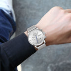 MEGIR 2011 men's chronograph watch on the wrist, silver case with white dial and silver mesh bracelet, close-up