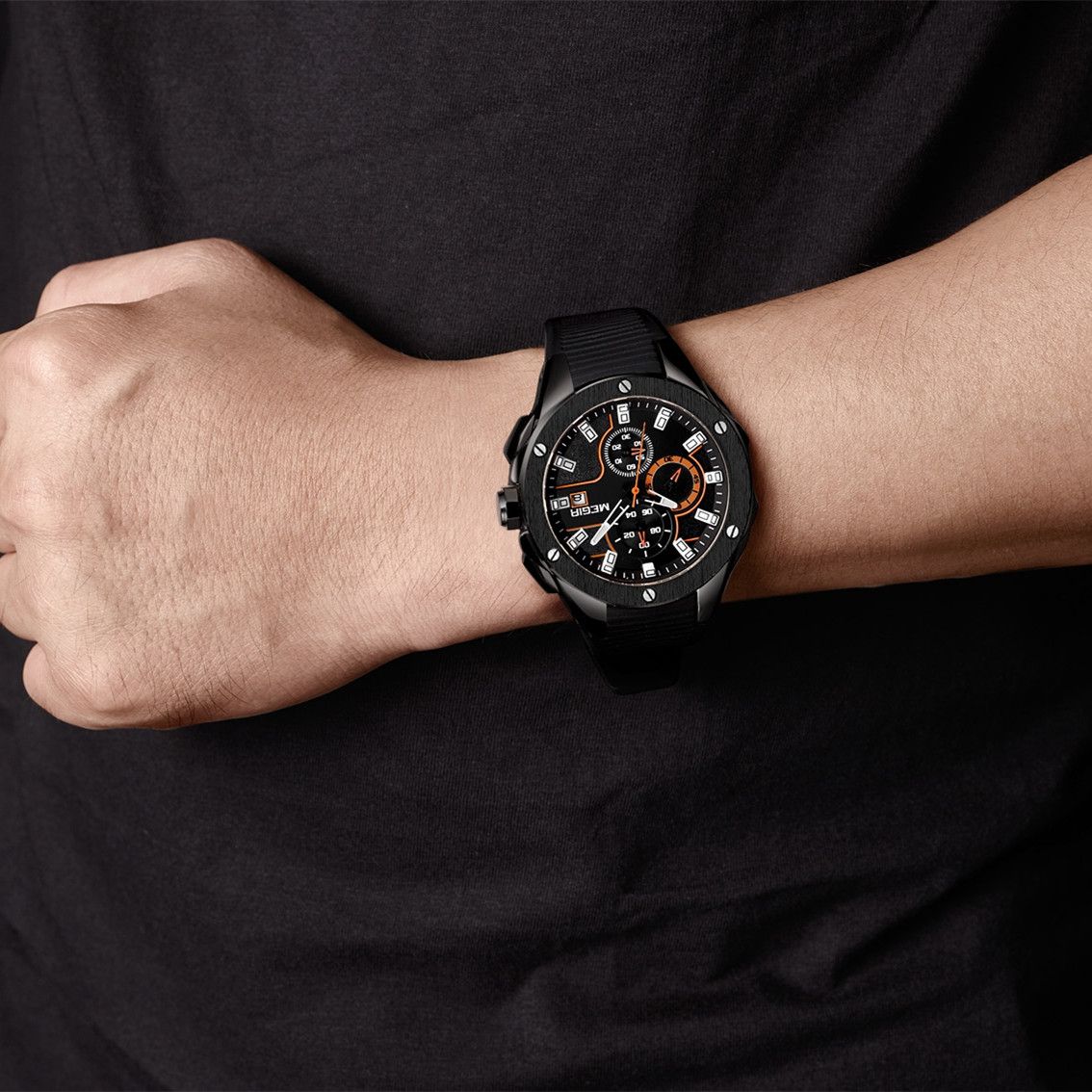 MEGIR 2053 men's chronograph watch on the wrist, all-black case with black dial, orange accents and black silicone strap