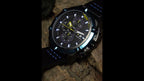 MEGIR 2062 men's chronograph watch product video thumbnail, black case with blue bezel on a wood surface