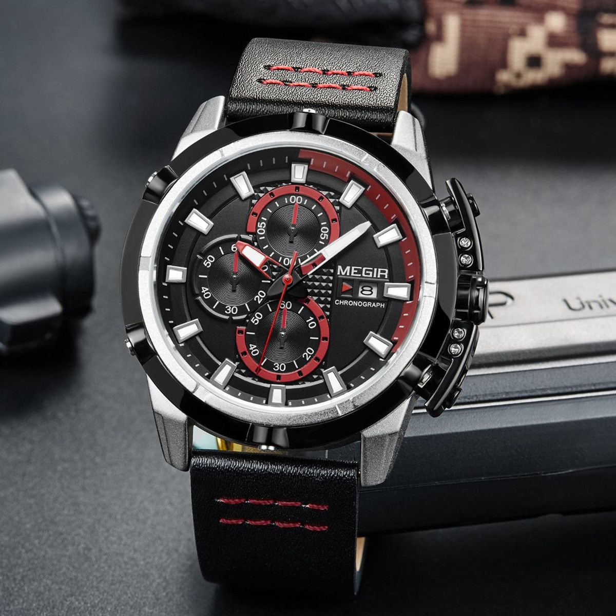 MEGIR 2062 men's chronograph watch, silver case with black dial, red accents and black leather strap, angled view