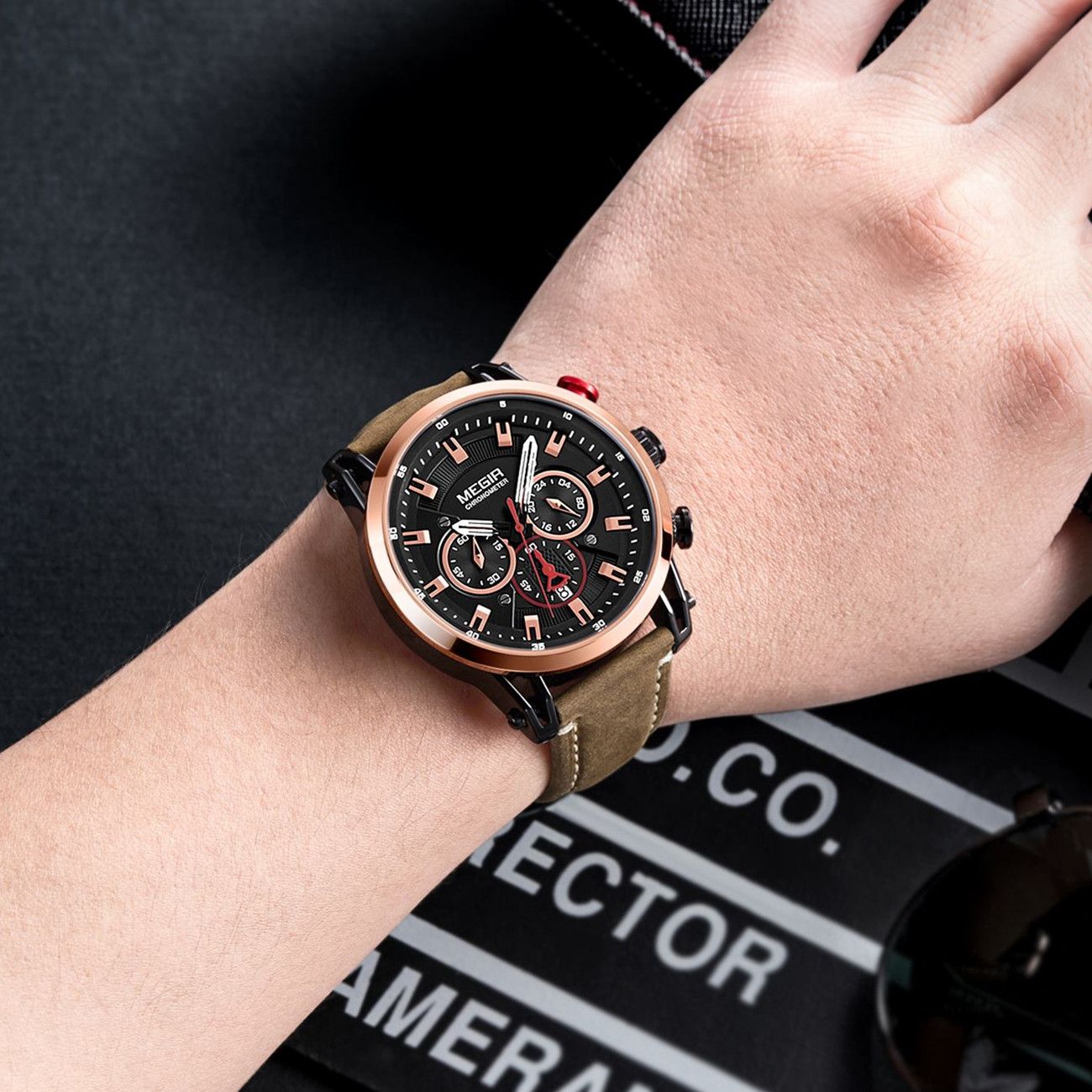 MEGIR 2085 men's chronograph watch on the wrist, rose-gold bezel with black dial and brown leather strap