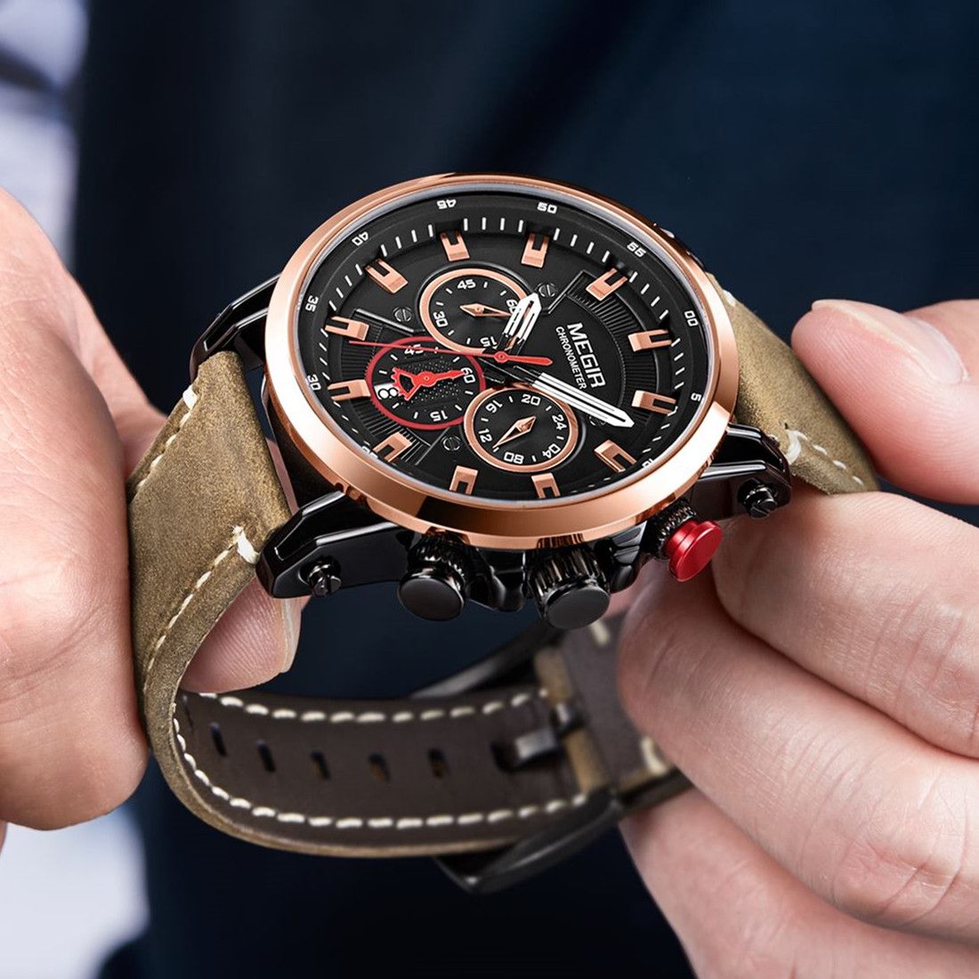 MEGIR 2085 men's chronograph watch held in hand, rose-gold bezel with black dial and brown leather strap