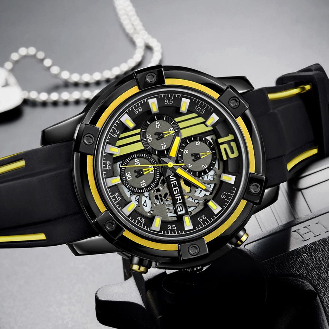 MEGIR 2097 men's chronograph watch, black case with black dial, yellow accents and black silicone strap, angled view