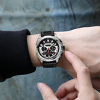 MEGIR 2128 men's chronograph watch on the wrist, silver case with black dial and black leather strap, close-up
