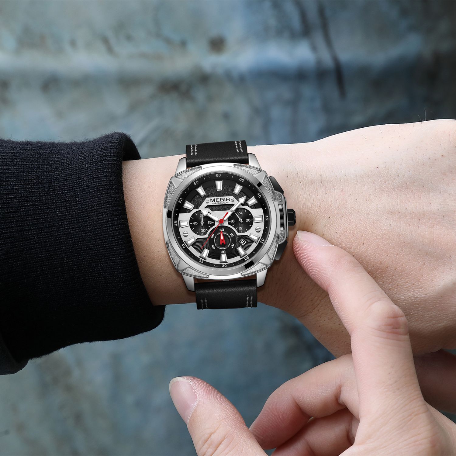 MEGIR 2128 men's chronograph watch on the wrist, silver case with black dial and black leather strap, close-up
