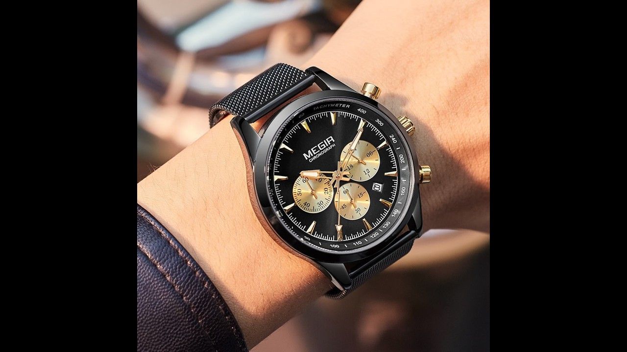 MEGIR 2153 men's chronograph watch on the wrist, black case with black dial, gold sub-dials and black mesh bracelet, close-up