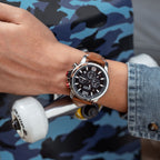 MEGIR 2156 men's chronograph watch on the wrist, silver case with black dial and brown leather strap, close-up
