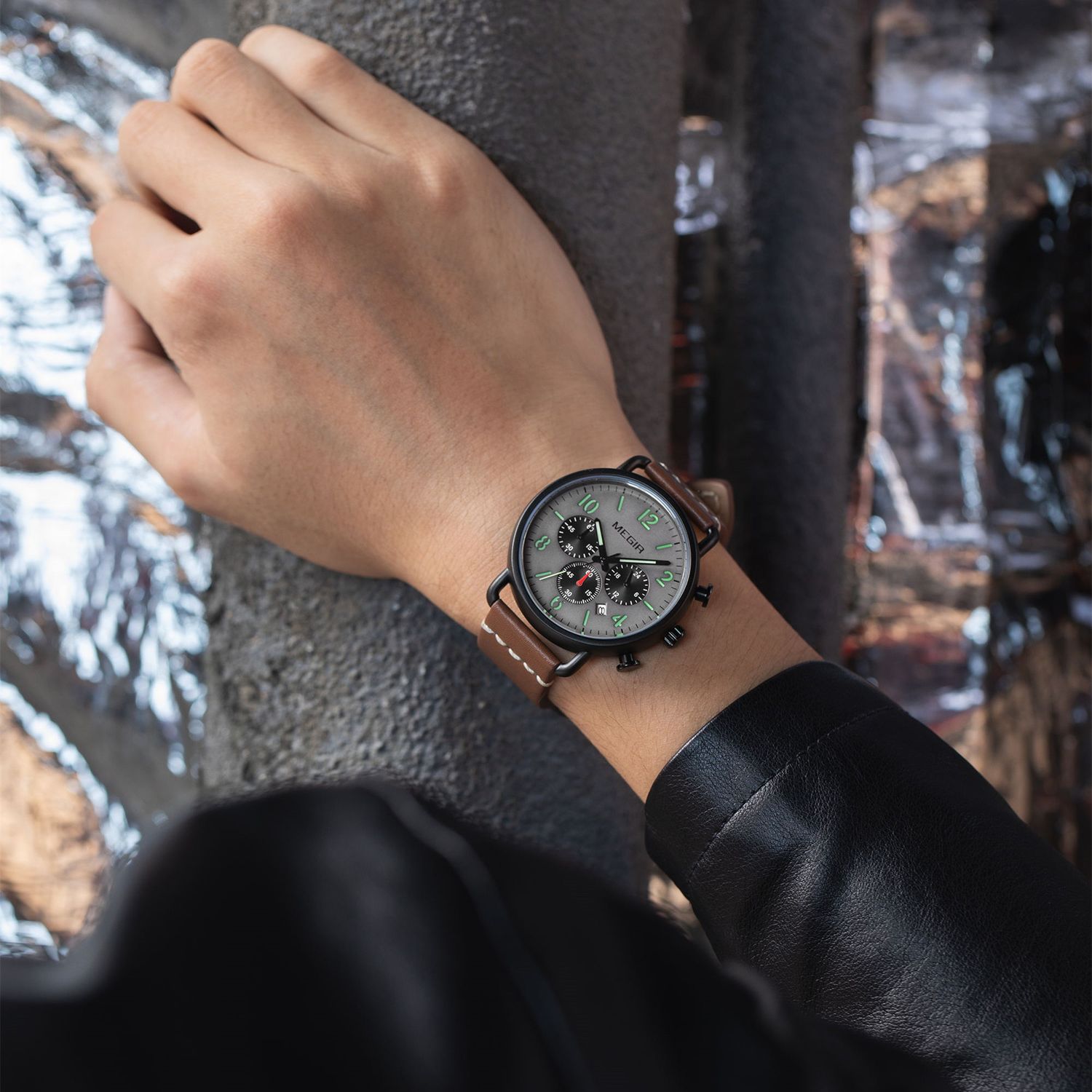 MEGIR 2158 men's chronograph watch on the wrist, black case with grey dial and brown leather strap, close-up
