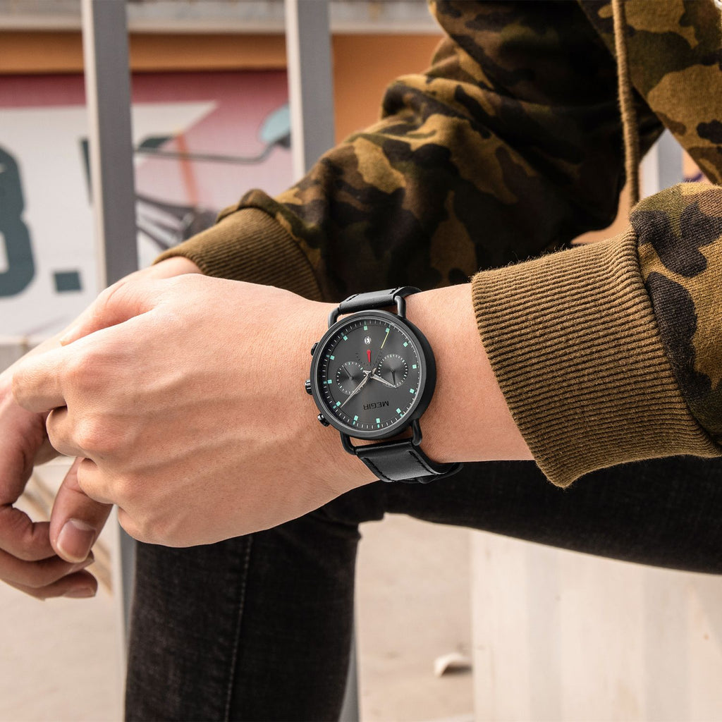 MEGIR 2159 men's chronograph watch on the wrist, black case with grey dial and black leather strap, side view
