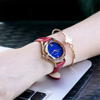 MEGIR 4208 women's quartz watch on the wrist, rose-gold faceted case with blue dial and red leather strap
