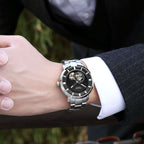 MEGIR 62052 skeleton automatic watch on the wrist, silver case and bracelet with black open-heart dial, outdoors