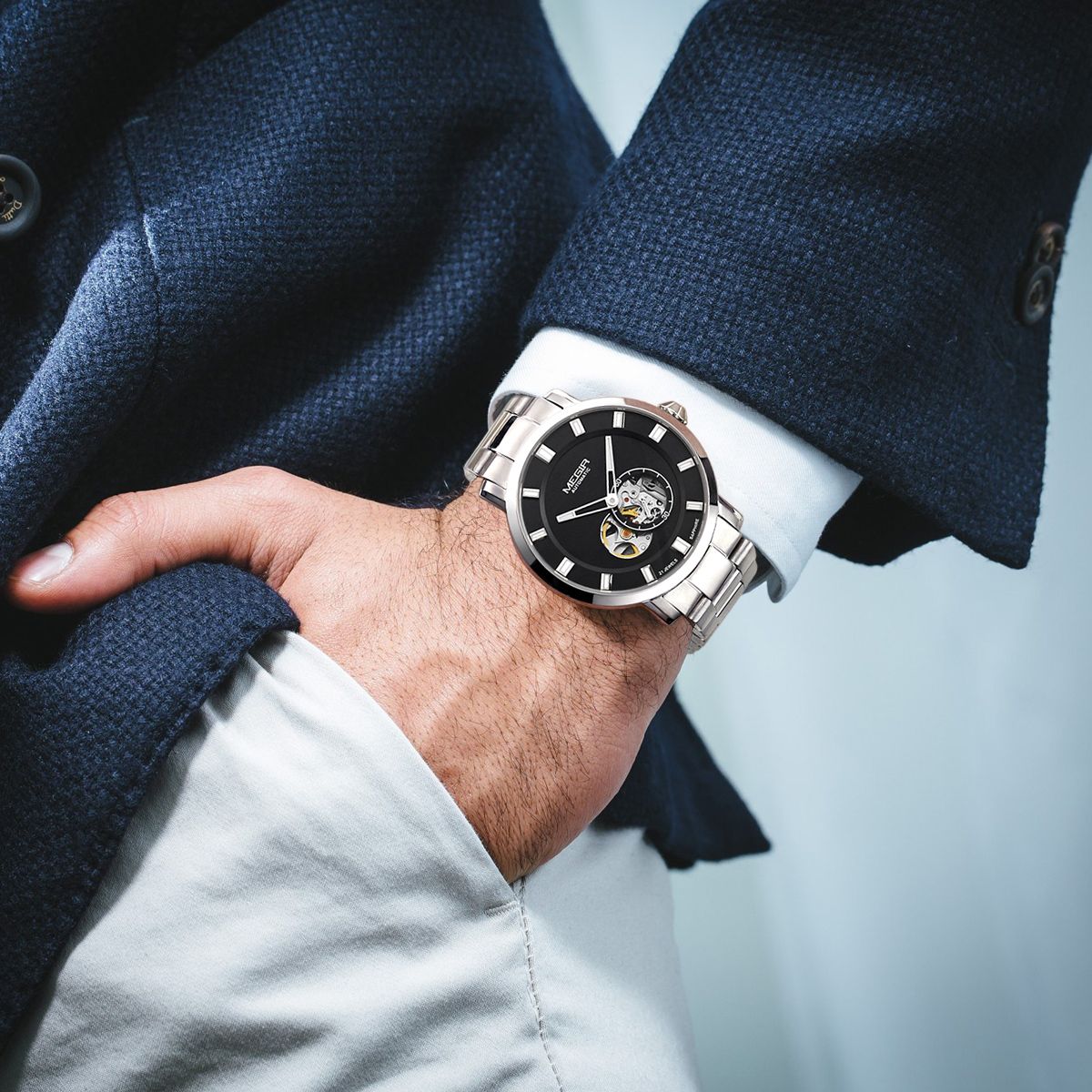 MEGIR 62052 skeleton automatic watch on the wrist, silver case and bracelet with black open-heart dial, with jacket