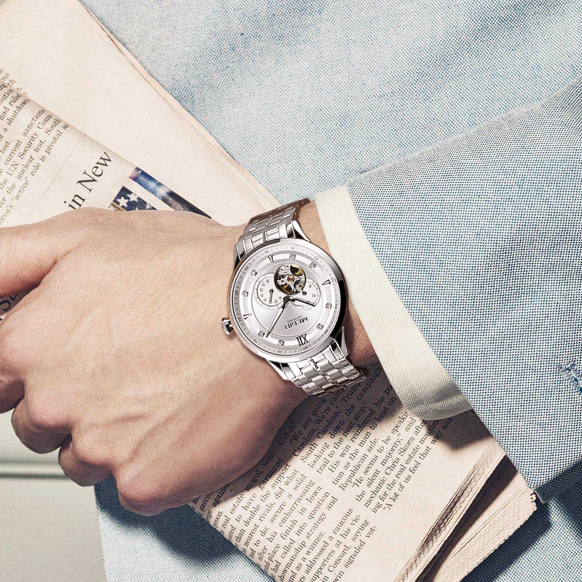 MEGIR 62053 automatic watch on the wrist, silver case and bracelet with white open-heart dial, with newspaper