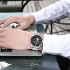 MEGIR 62053 automatic watch on the wrist, silver case and bracelet with black open-heart dial, at a laptop