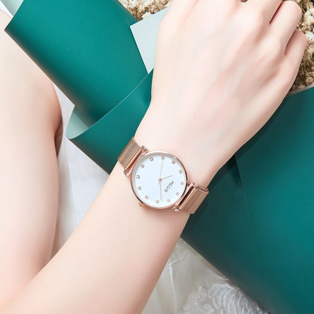 MEGIR 7001 quartz watch on the wrist, rose-gold mesh bracelet and white crystal-marker dial, resting on the arm