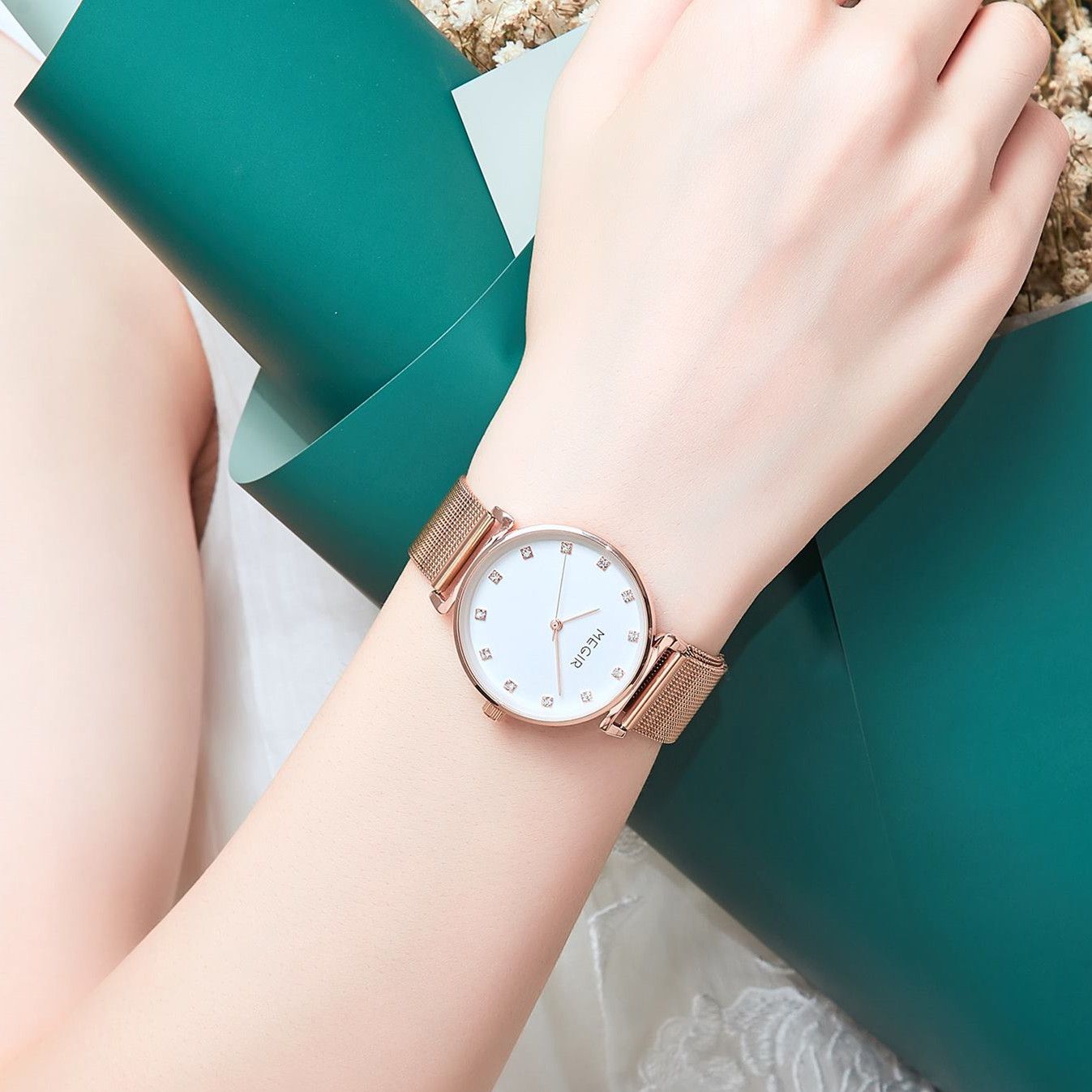 MEGIR 7001 quartz watch on the wrist, rose-gold mesh bracelet and white crystal-marker dial, resting on the arm