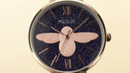 MEGIR 7009 women's quartz watch dial close-up, dark-blue starry face with rose-gold bee and Roman numerals