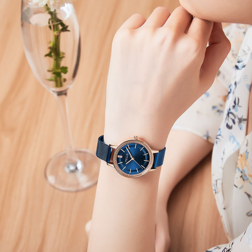 MEGIR 7012 quartz watch on the wrist, rose-gold case, blue dial and blue mesh bracelet, with champagne glass