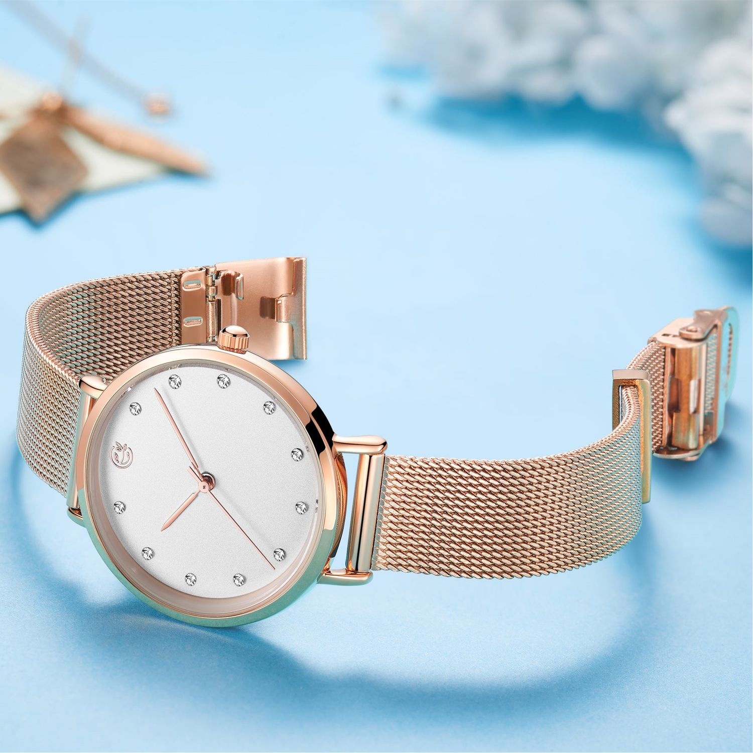 MEGIR 7022 women's quartz watch, white dial and rose-gold mesh bracelet, styled on blue background