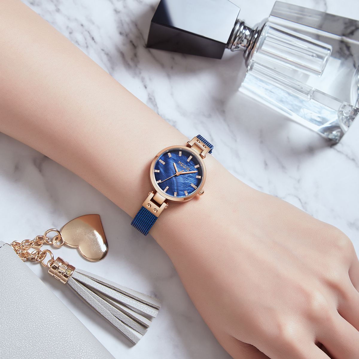 MEGIR 7025 quartz watch on the wrist, blue dial and blue mesh bracelet, styled with perfume