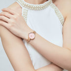 MEGIR 7025 quartz watch on the wrist, pink dial and rose-gold mesh bracelet, arm crossed