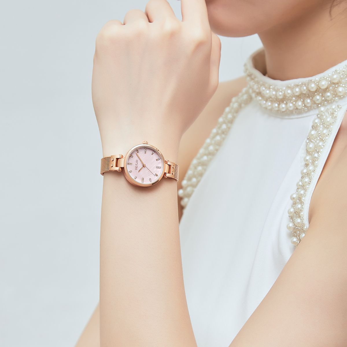 MEGIR 7025 quartz watch on the wrist, pink dial and rose-gold mesh bracelet, worn with pearls