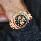 Men's chronograph watch on the wrist, rose-gold case, rainbow crystal bezel and black dial