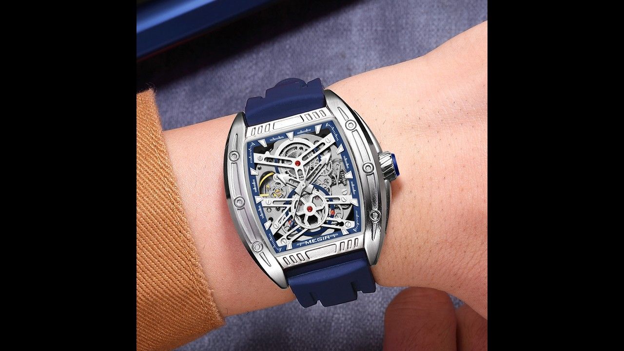 MEGIR 8601 skeleton automatic watch on the wrist, silver case and blue silicone strap, close-up