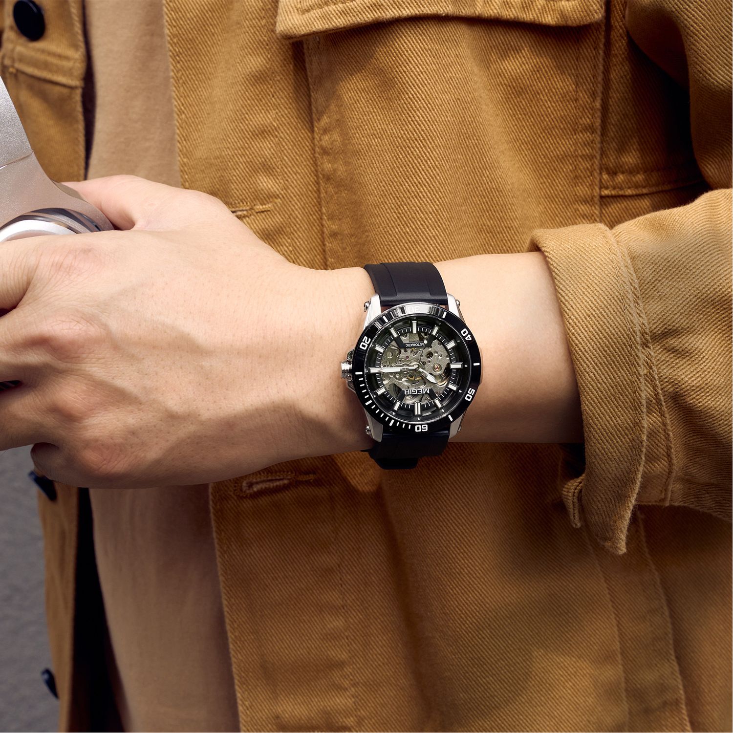 MEGIR 8605 skeleton automatic watch on the wrist, silver case, black bezel and black silicone strap