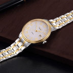 MEGIR 96001 two-tone automatic watch, profile showing gold bezel and bracelet, on a wooden surface