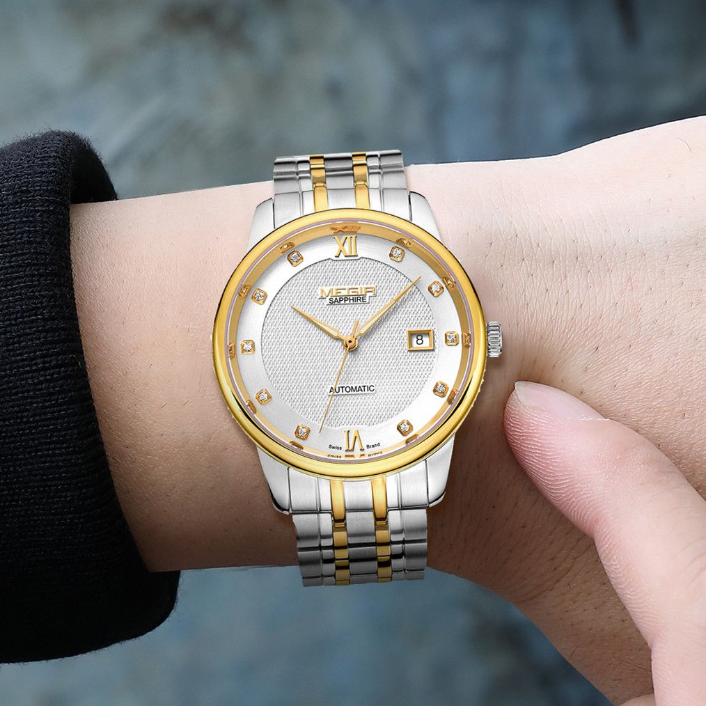 MEGIR 96002 two-tone automatic watch shown on a wrist, white dial and gold bezel, blue background