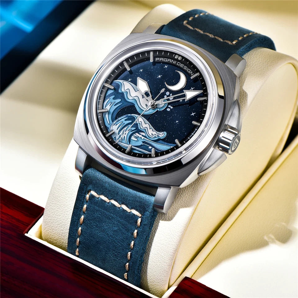 Angled view of Pagani Design H35A automatic mechanical watch with blue wave dial, silver case, and dark blue suede strap displayed on a cushion.