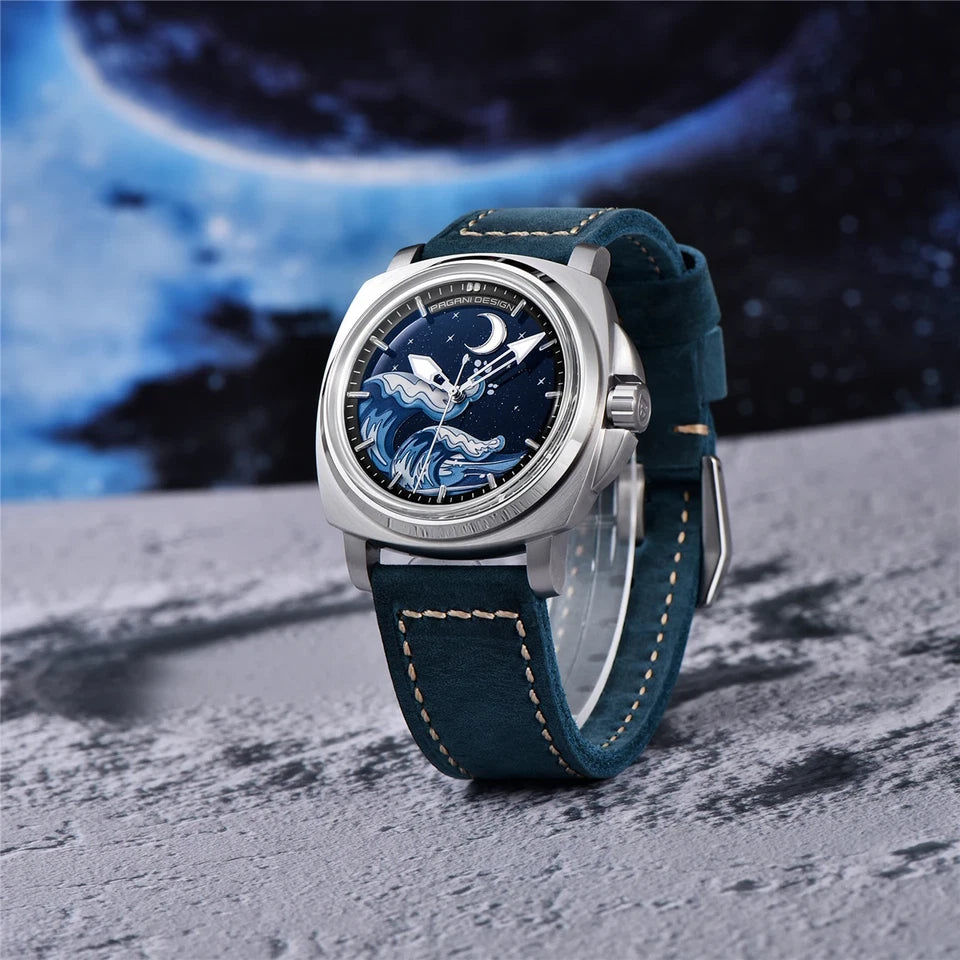 Lifestyle image of Pagani Design H35A automatic mechanical watch with blue wave dial, silver case and dark blue suede strap, displayed on a rocky surface with a moon backdrop.