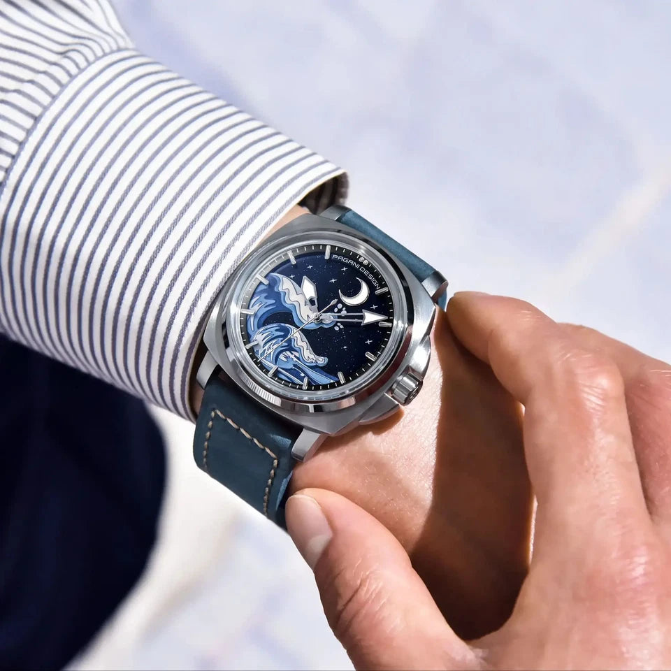 Wrist shot of Pagani Design H35A automatic mechanical watch with blue wave dial, silver case and dark blue suede strap on a person's wrist.