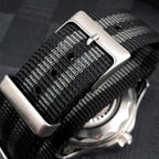 PAGANI DESIGN nylon strap macro showing brushed silver buckle on black and grey striped weave