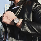 PAGANI Design PD-1654 dress watch with white dial and rose gold case on wrist with leather jacket