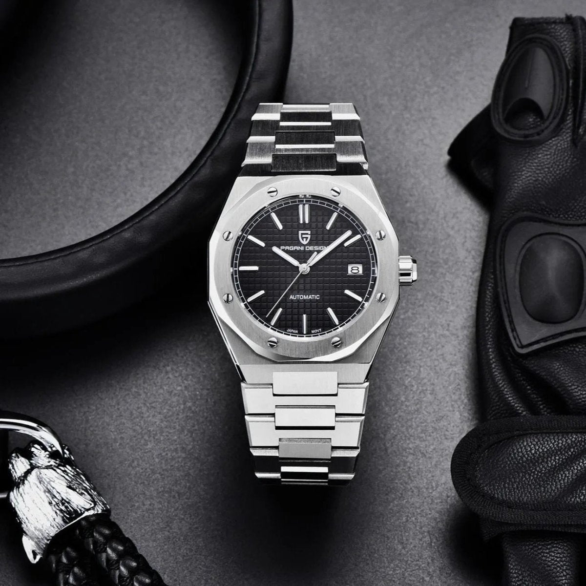 Pagani Design PD-1673 black dial flatlay with leather gloves, showing bracelet and date window at 3