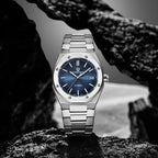 Pagani Design PD-1673 blue dial upright on rock, showing octagonal bezel screws and date window