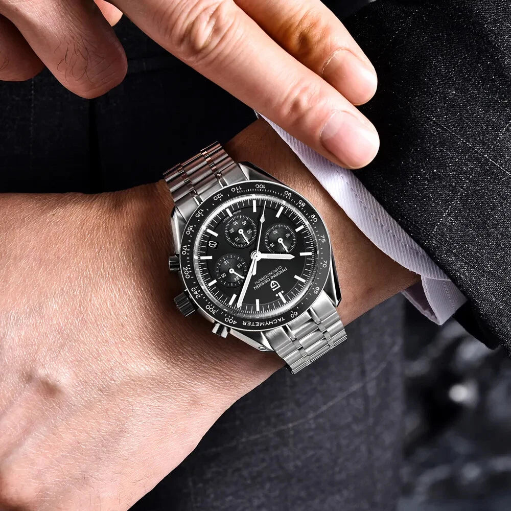 Wrist shot of Pagani Design PD-1701 chronograph watch with black dial, stainless steel bracelet, black tachymeter bezel, and luminous hands.