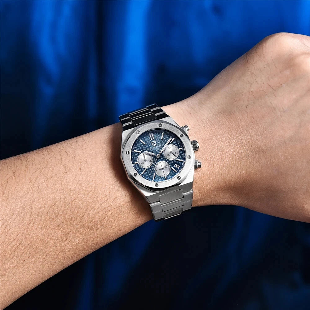 Wrist shot of Pagani Design PD-1707 chronograph quartz watch with blue dial and stainless steel bracelet, worn on the wrist with a blue fabric background.