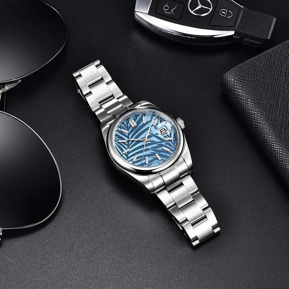 Lifestyle flat lay of Pagani Design PD 1715 automatic watch blue patterned dial stainless steel bracelet on dark surface
