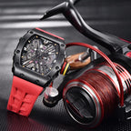 PAGANI DESIGN PD-1738 MILLE skeleton watch with red rubber strap beside fishing reel prop