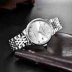 Pagani Design PD-1759 silver dial dress watch resting on brown leather, steel bracelet and date