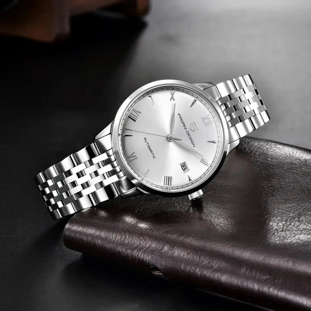 Pagani Design PD-1759 silver dial dress watch resting on brown leather, steel bracelet and date