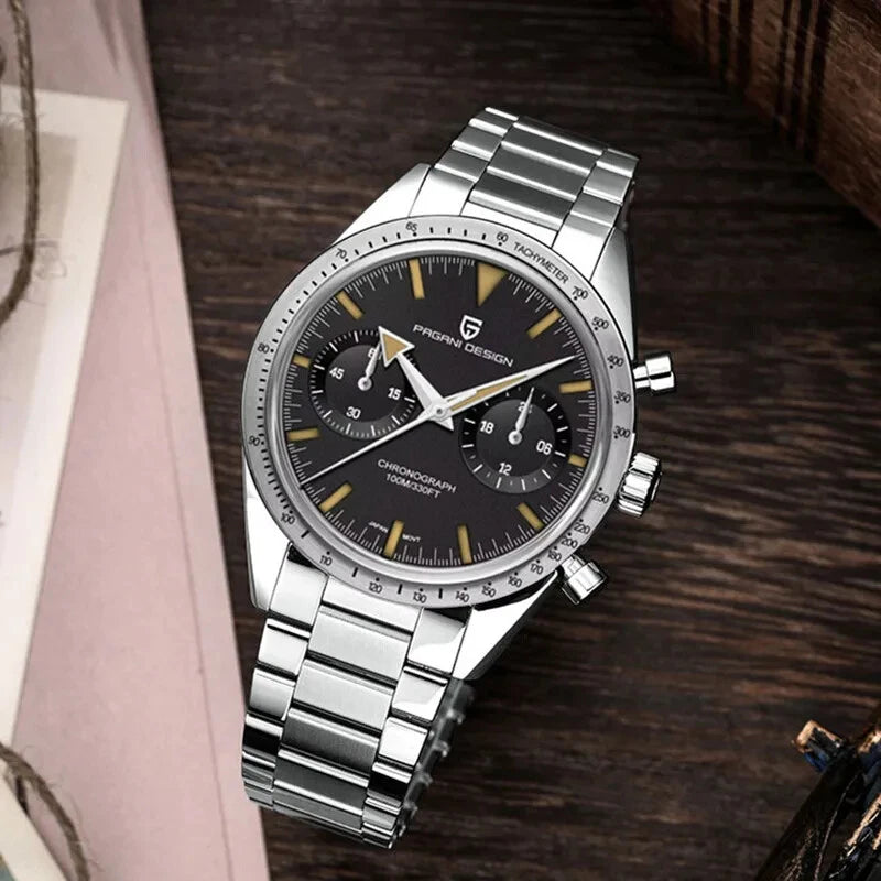 Flat lay lifestyle image of Pagani Design PD-1766 men's moon quartz chronograph watch with a black dial, gold-tone markers, chronograph subdials, tachymeter bezel, stainless steel case, and matching stainless steel bracelet, placed on a wooden surface with a rustic background.