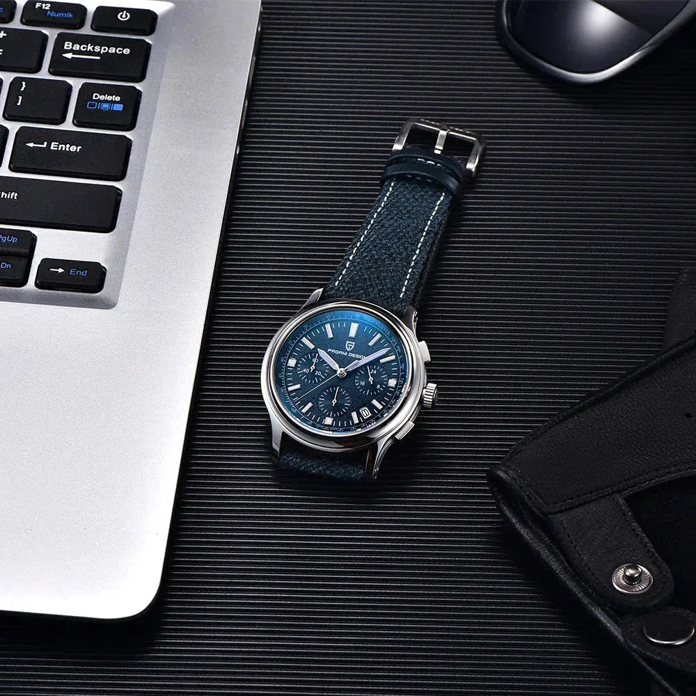 Pagani Design PD-1781 blue chronograph laid flat beside a laptop and sunglasses