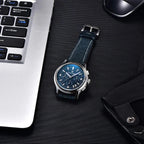 Pagani Design PD-1781 blue chronograph laid flat beside a laptop and sunglasses