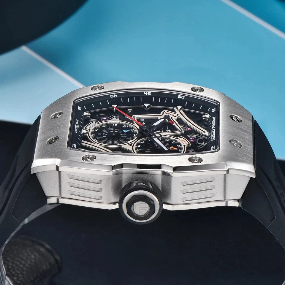 Side view of Pagani Design PD‑YS012 skeleton sport watch featuring black rubber strap and silver tonneau case with crown, against a blue and black background, showcasing the skeleton dial and chronograph subdials.